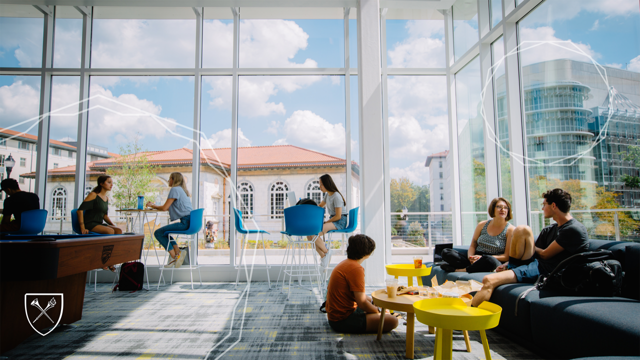 students sitting inside the student center with view of campus outside large windows
